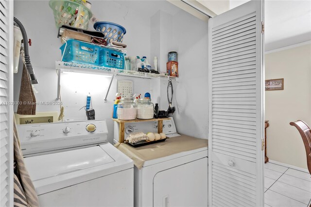 laundry room with independent washer and dryer and light tile patterned flooring