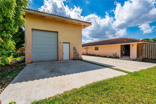 back of house featuring a garage and a yard