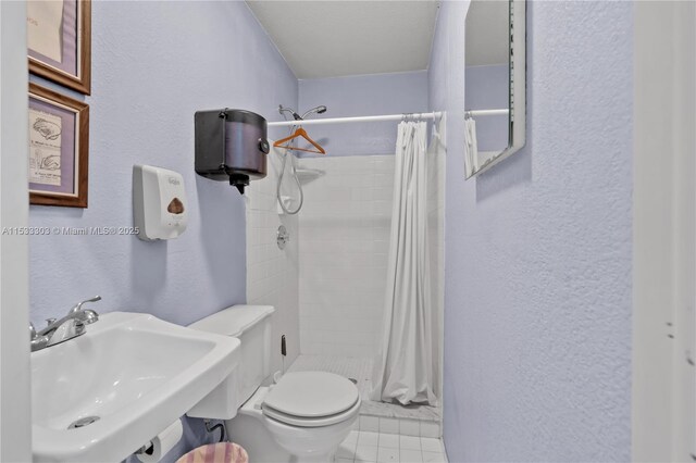 bathroom featuring tile patterned flooring, toilet, sink, and walk in shower