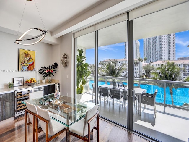 dining space featuring a wall of windows, beverage cooler, and hardwood / wood-style floors