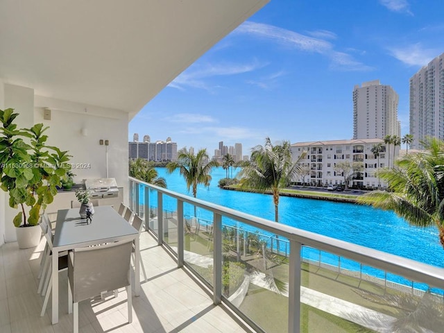 balcony with a water view and area for grilling