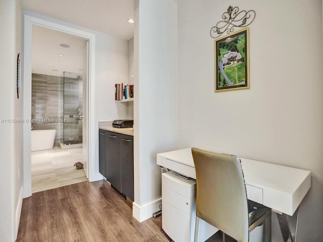 office space with built in desk and light hardwood / wood-style flooring