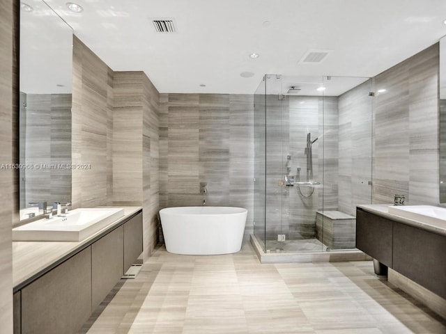 bathroom with vanity, tile walls, and separate shower and tub