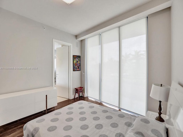 bedroom with dark hardwood / wood-style flooring