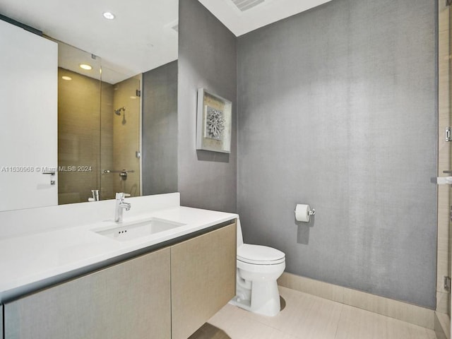 bathroom with tile patterned floors, vanity, toilet, and a shower