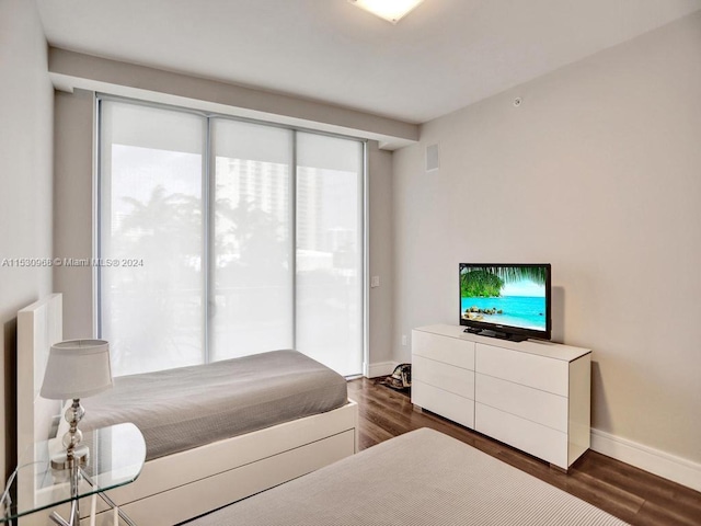 bedroom featuring dark hardwood / wood-style floors and access to outside