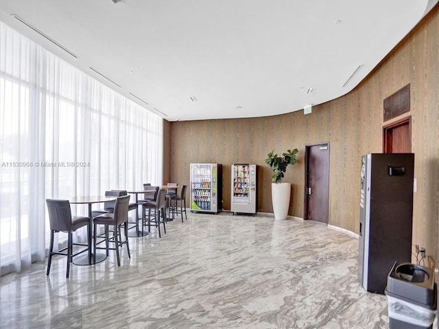 dining room with a wealth of natural light and wood walls