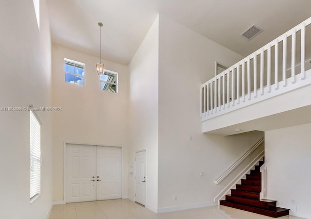 entryway with a high ceiling and light tile floors