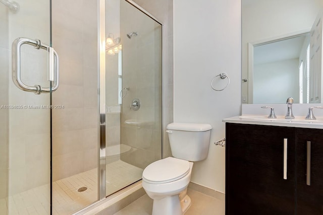 bathroom featuring toilet, tile flooring, a shower with shower door, and oversized vanity