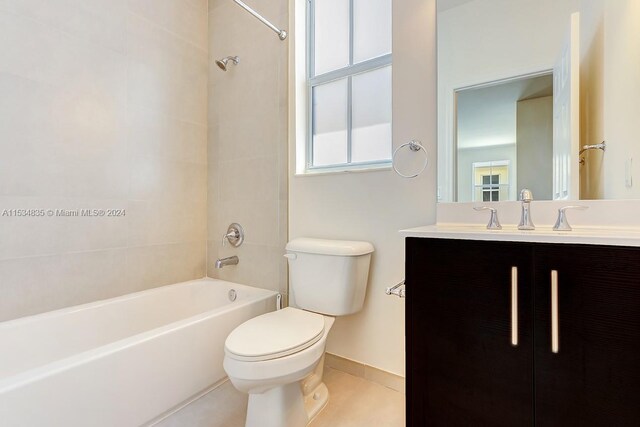 full bathroom featuring tiled shower / bath, toilet, tile floors, and vanity