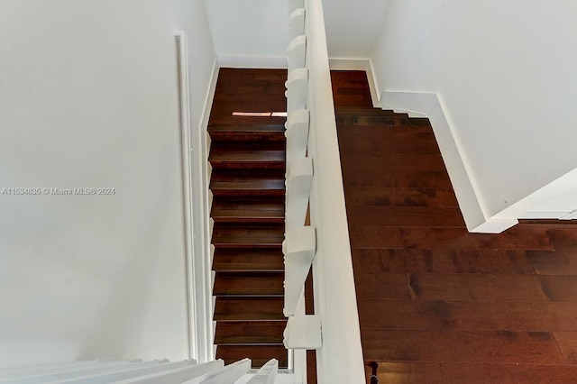 stairway with dark hardwood / wood-style floors