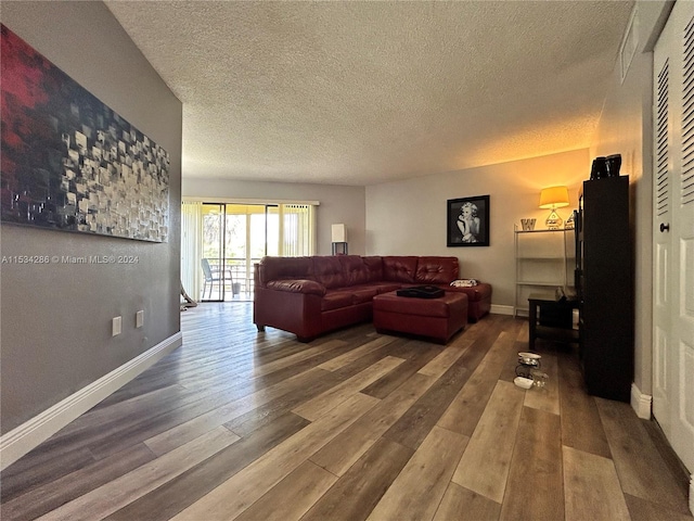 living room featuring dark hardwood / wood-style flooring and a textured ceiling