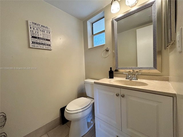 bathroom featuring toilet, tile floors, and vanity