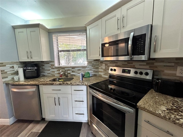 kitchen with light stone countertops, sink, light wood-type flooring, stainless steel appliances, and white cabinets