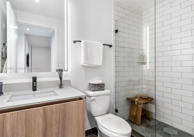 bathroom with an enclosed shower, toilet, vanity, and tile floors