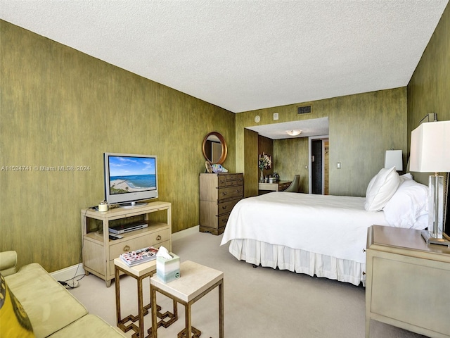 carpeted bedroom with wood walls and a textured ceiling