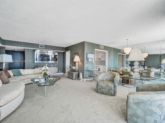 carpeted living room featuring a notable chandelier and a textured ceiling