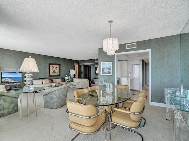 dining room with a chandelier, light carpet, and a textured ceiling