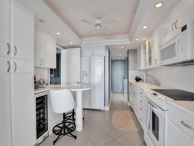 kitchen featuring white appliances, ceiling fan, a tray ceiling, wine cooler, and white cabinetry