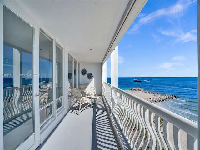 balcony with a water view and a beach view