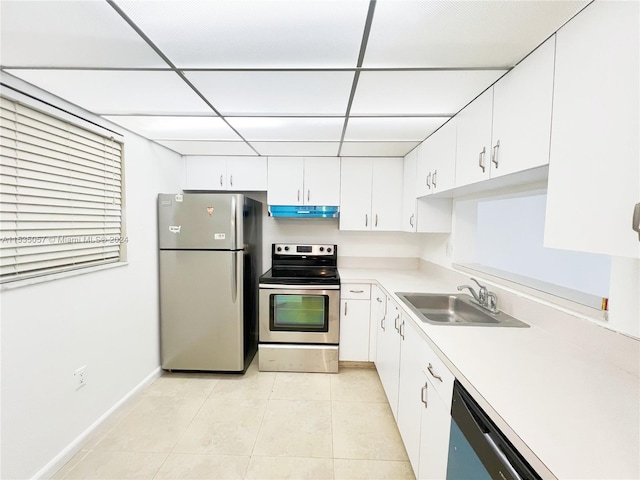 kitchen with a drop ceiling, white cabinets, sink, and stainless steel appliances