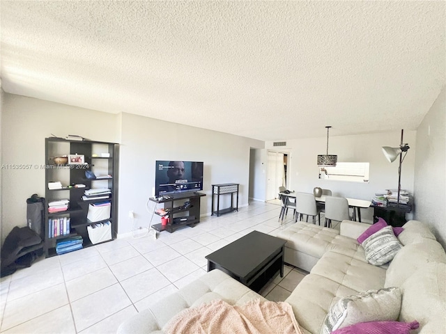 living room featuring a textured ceiling and light tile patterned floors