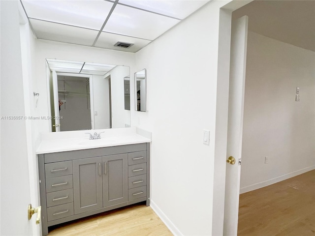 bathroom featuring vanity, a drop ceiling, and hardwood / wood-style flooring