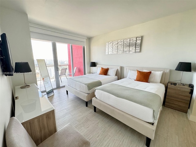 bedroom featuring access to exterior and light wood-type flooring