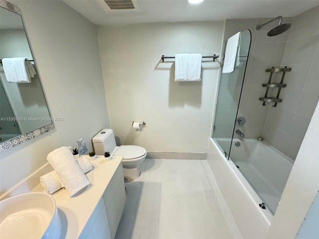 full bathroom featuring tiled shower / bath, toilet, tile floors, and oversized vanity