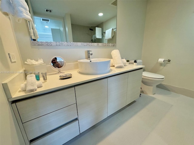 bathroom with toilet, vanity, and tile flooring