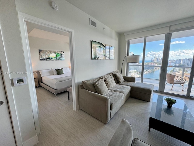 living room with a water view, light hardwood / wood-style floors, and french doors