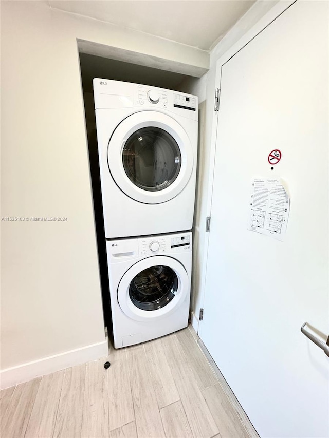 clothes washing area with stacked washer / dryer and light wood-type flooring