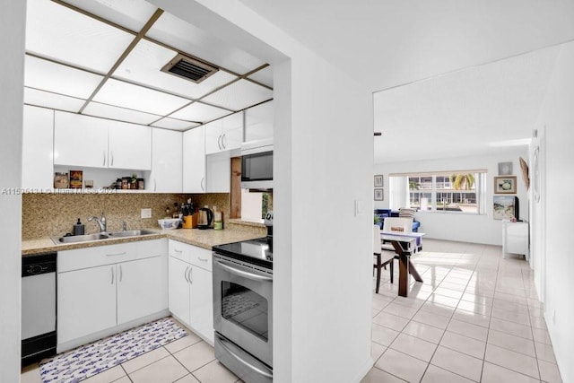 kitchen featuring light tile patterned floors, white cabinetry, sink, and appliances with stainless steel finishes