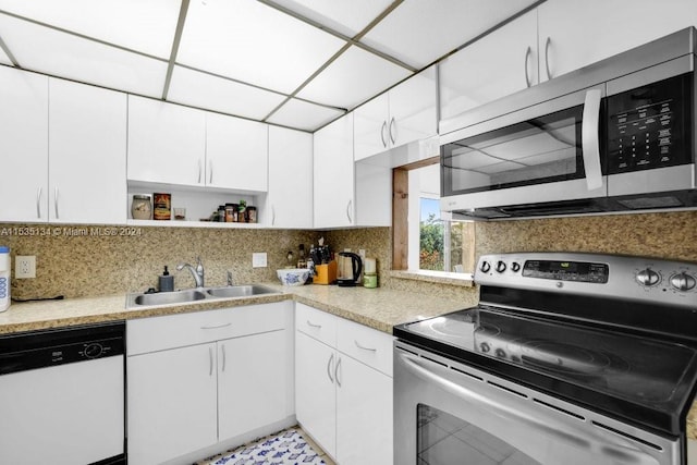 kitchen with white cabinets, sink, stainless steel appliances, and tasteful backsplash