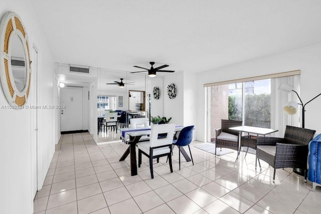 tiled dining space with ceiling fan and a healthy amount of sunlight