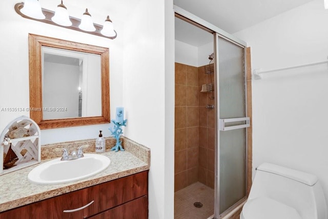 bathroom with vanity, toilet, and a shower with shower door