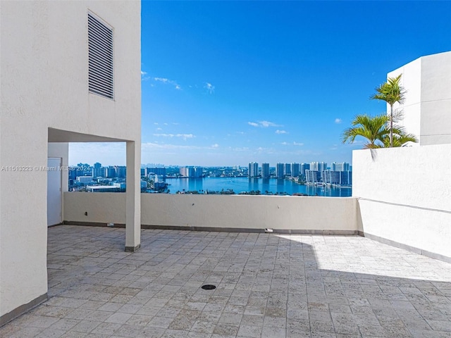 view of patio with a water view and a balcony