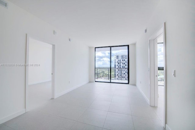 tiled spare room featuring expansive windows