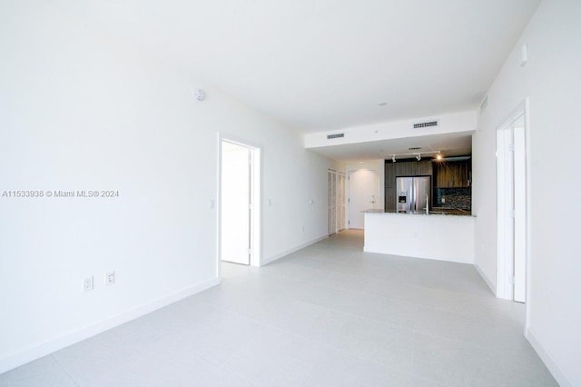 unfurnished living room with light tile floors