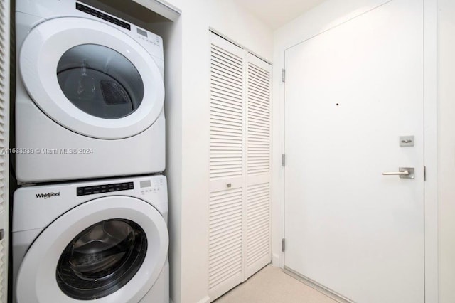 washroom with stacked washing maching and dryer