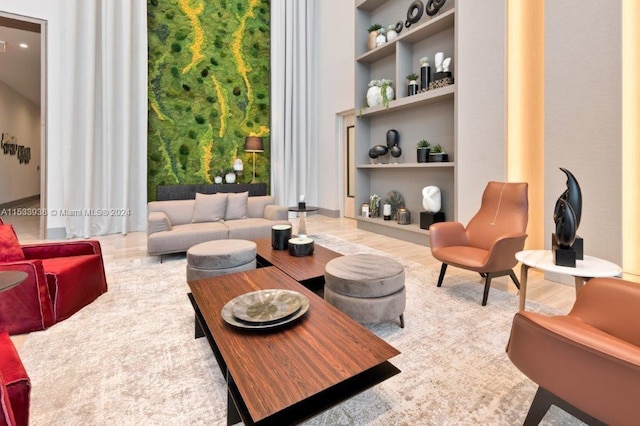 living area featuring light wood-type flooring and built in shelves