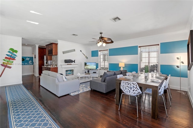 living room featuring ornamental molding, ceiling fan, and dark hardwood / wood-style floors