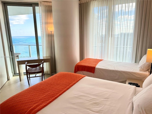 tiled bedroom with a water view and access to outside