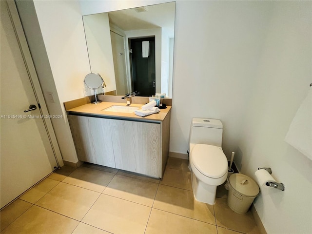 bathroom with tile floors, large vanity, and toilet