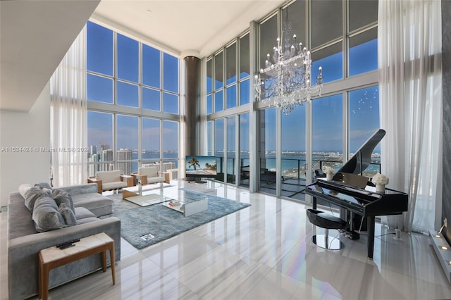 living room with floor to ceiling windows, an inviting chandelier, a water view, and a high ceiling