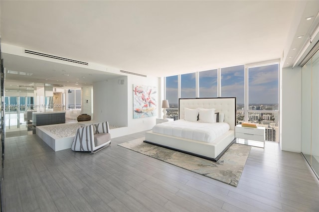 bedroom featuring floor to ceiling windows, multiple windows, and hardwood / wood-style flooring