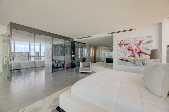 bedroom featuring floor to ceiling windows and light hardwood / wood-style flooring