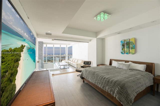 bedroom featuring expansive windows and dark wood-type flooring