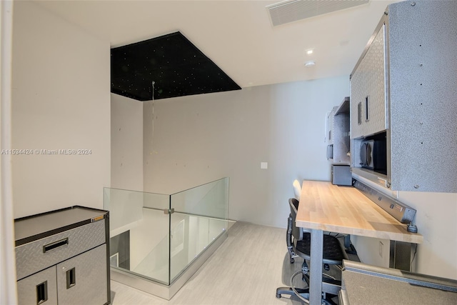 home office with light hardwood / wood-style flooring