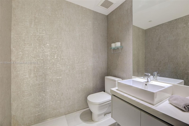 bathroom featuring vanity, tile floors, toilet, and tile walls